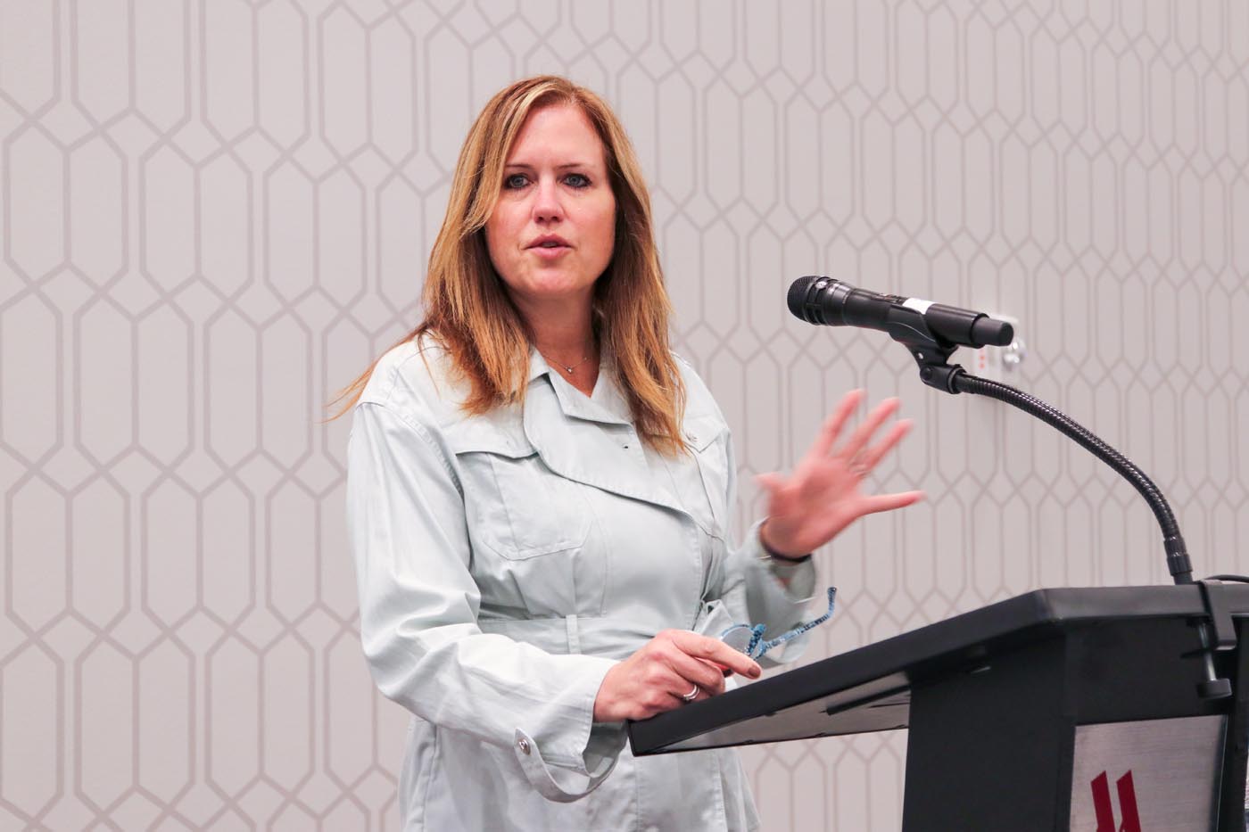 Dr. Laura Justice stands at a podium speaking to an audience.