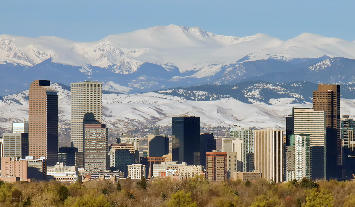 The skyline of Denver, Colorado, set against the backdrop of the Rocky Mountains